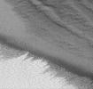 NASA's Mars Global Surveyor shows the edge of Mars' retreating polar cap as a bright, wind-streaked surface. Rdges, tiny buttes and pits are part of the polar cap's layered deposits.