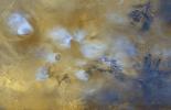 NASA's Mars Global Surveyor shows the Tharsis volcanoes (mostly covered by bluish-white water ice clouds) and the Valles Marineris trough system on Mars in April 1999.