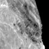 View of Miranda showing light and dark banded scarps near the boundary of the banded ovoid and a deep graben that bounds the ovoid in this region.