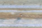 Taken by NASA's Cassini spacecraft, a small white spot, probably a thunderstorm, lies to the south of a larger, brown spot on Jupiter.