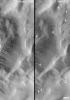 NASA's Mars Global Surveyor shows a portion of Lycus Sulci, a rugged, ridged terrain north of the giant Olympus Mons volcano on Mars. Dark streaks considered to result from the avalanching of dry, fine, bright dust.