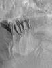 NASA's Mars Global Surveyor shows deep gullies cut into the wall of a south mid-latitude crater on Mars. Erosion has exposed layers in the upper wall of the crater.