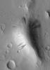 NASA's Mars Global Surveyor shows dark slope streaks coming down the slopes of a knob in western Amazonis Planitia on Mars. All of the surfaces are mantled by dust. On the slopes, mass movement of dry dust has created the streaks.