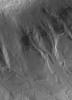 NASA's Mars Global Surveyor shows gullies formed in material on the walls of an impact crater in the martian southern hemisphere. A liquid, laden with debris, poured down these slopes to form the gullies.