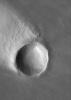 NASA's Mars Global Surveyor shows a crater in the Memnonia region of Mars, around which has formed a wind streak.