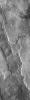 This image from NASA's Mars Odyssey spacecraft shows overlapping flows with different suface textures. In the middle of the image there is a round, darker feature, a small volcano. To the left of the volcano a graben cuts across the lava flows.