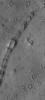 NASA's Mars Global Surveyor shows a curved, pitted ridge in Isidis Planitia on Mars. This feature may be a remnant of a once more-extensive layer of material that covered the present, cratered surface.