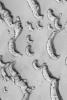 NASA's Mars Global Surveyor shows frost-covered north polar sand dunes in springtime as they are beginning to defrost. Dark spots and streaks indicate areas where frozen carbon dioxide has started to be removed by sublimation and wind.