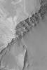NASA's Mars Global Surveyor shows some of the layer outcrops in Terby Crater on Mars. Fans of debris have eroded from the steep, layered slopes in some places.
