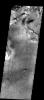 This image from NASA's 2001 Mars Odyssey released on Nov 20, 2003 is located near the boundary between Syrtis Major and Isidis Planitia shows rough material eroded away from an underlying surface with many small craters.
