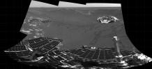 This partial panoramic image from NASA's Mars Exploration Rover Opportunity shows the lander in the center of the crater at Meridiani Planum, Mars. In view are plains outside the crater, the rover tracks, and the airbag bounce marks behind the lander.