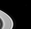 Gazing beyond Saturn's magnificent rings, NASA's Cassini spacecraft spotted the cause of the dark gap visible in the foreground of this image: Mimas, which is 398 kilometers (247 miles) wide.