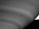 NASA's Cassini spacecraft caught this intriguing view of a dark storm near the limb of Saturn on Sept. 9, 2004.