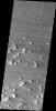 This image released on July 23, 2004 from NASA's 2001 Mars Odyssey shows that eons of atmospheric dust storm activity has left its mark on Mars such small ridges that remain have been ground down to a cliff-face with a 'tail' of eroded material. 