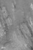 NASA's Mars Global Surveyor shows the central peak of Oudemans Crater on Mars containing light-toned, layered rock that has been uplifted and severely tilted.