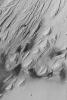 NASA's Mars Global Surveyor shows the effects of severe wind erosion of layered sedimentary rock in the Aeolis region of Mars. The sharp ridges formed by wind movement are known as yardangs.