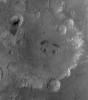 NASA's Mars Global Surveyor shows Tikhonravov Crater in central Arabia Terra on Mars. Two impact craters at its center that have dark patches of sand in them, giving the impression of pupils in two eyes.