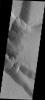 This image taken by NASA's Mars Odyssey shows part of the caldera of Tharsis Tholus on Mars; fractures are visible in the cliff wall it is possible to see that the fractures dip to the north.