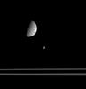 The Saturn moon Mimas is much smaller than Rhea, but the geometry of this scene exaggerates the actual differences in size. Here, Mimas is on the opposite side of the rings from Rhea and NASA's Cassini spacecraft.