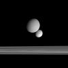The moons Dione and Tethys face each other across the gulf of Saturn's rings. Here, NASA's Cassini spacecraft looks on the Saturn-facing hemisphere of Tethys below and the anti-Saturn side of Dione above.