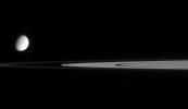 This view from NASA's Cassini spacecraft contains not one, but two moons. Tethys is slightly overexposed so that the real target of this image, tiny Atlas, can be seen. Atlas is at image center, just outside the A ring.
