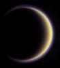 With its thick, distended atmosphere, Titan's orange globe shines softly, encircled by a thin halo of purple light-scattering haze as seen by NASA's Cassini spacecraft.