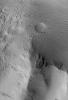 NASA's Mars Global Surveyor shows a small mountain in the Lycus Sulci region, northwest of the Olympus Mons volcano on Mars. Dark streaks, probably caused by avalanching and flow of extremely dry dust, have formed on the mountain's slopes.