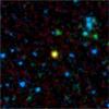 This false-color image from NASA's Spitzer Space Telescope shows a distant galaxy (yellow) that houses a quasar, a super-massive black hole circled by a ring, or torus, of gas and dust.