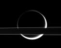 Titan's smoggy atmosphere glows brilliantly in scattered sunlight, creating a thin, gleaming crescent beyond Saturn's rings. This image was taken in visible light with NASA's Cassini spacecraft's narrow-angle camera on Jan. 18, 2006.