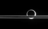 Titan shines beyond the rings like a brilliant ring of fire, its light gleaming here and there through the gaps in Saturn's magnificent plane of ice. This image was taken in visible light with NASA's Cassini spacecraft's narrow-angle camera.