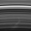 A bright spoke extends across the unilluminated side of Saturn's B ring about the same distance as that from London to Cairo. The background ring material displays some azimuthal asymmetry as seen by NASA's Cassini spacecraft.