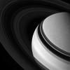 Held in gravity's embrace, Saturn's darkened, icy rings encircle the clouded gas giant as seen by NASA's Cassini spacecraft.