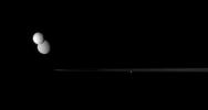 NASA's Cassini spacecraft captures a gathering of three moons, Tethys, Rhea, and Pandora, near the rings' outer edge as the icy worlds dutifully march about Saturn.