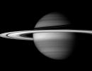 Saturn's incredible rings dwarf its moons in sheer scale. But all of their material, if compacted into a single body, would make a moon smaller than Enceladus, captured by NASA's Cassini spacecraft next to the planet's banded globe.