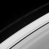 Two of Saturn's ring moons, Pan and Atlas, are captured in this view from NASA's Cassini spacecraft, along with the signature of another. This image was taken not long after Prometheus passed, leaving a trail of dark gores in the inner edge of the F ring.