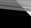 Saturn's brilliant limb shines through the semi-transparent A ring, while the outer F ring shepherd moon, Pandora, hangs against the black sky in this image from NASA's Cassini spacecraft taken on Apr. 5, 2008.