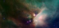 Newborn stars peek out from beneath their natal blanket of dust in this dynamic image of the Rho Ophiuchi dark cloud from NASA's Spitzer Space Telescope.