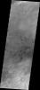 This image from NASA's Mars Odyssey shows individual, dark dunes located on the plains to the west of Hellas Basin. Other wind derived features are visible at the bottom of the frame.