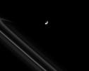 Saturn's moon Prometheus pulls away from an encounter with the narrow F ring, trailing a streamer of fine, icy particles behind it in this image captured by NASA's Cassini spacecraft on May 25, 2008.