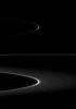 A bright arc within Saturn's faint G ring holds a tiny gift. A small moonlet is just visible as a short streak near the ansa of the G ring arc in the top of two versions of the same image from NASA's Cassini spacecraft taken on Jan. 28, 2009.