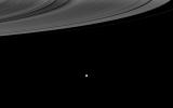 NASA's Cassini spacecraft looks past the illuminated side of Saturn's rings to the brilliant moon Enceladus.