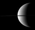 Dione's shadow is elongated as it is cast onto the round shape of Saturn in this image taken by NASA's Cassini spacecraft. The moon is not visible here. This view looks toward the northern, sunlit side of the rings from just above the ringplane.