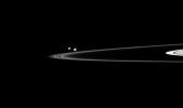 Two of Saturn's small moons can be seen orbiting beyond the planet's thin F ring in this image captured by NASA's Cassini spacecraft. Pandora is on the left, and Epimetheus is on the right.