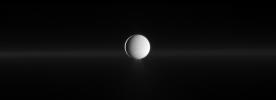 As Enceladus spews water ice from its south polar region, NASA's Cassini also shows Saturn's faint G ring before the moon.