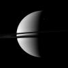 A small crescent of the moon Rhea is dwarfed by the larger crescent of Saturn in this image captured by NASA's Cassini spacecraft. Rhea can be seen in the upper right of the image.
