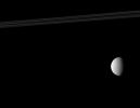 NASA's Cassini spacecraft composition features Saturn's rings (top of image), its second largest moon, Rhea (on right of image), and one of the planet's tiny moons, Telesto (near the middle of image) appears as a bright speck.