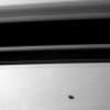 Saturn's moon Mimas casts a elliptical shadow on the planet south of the larger, wider shadows cast by t