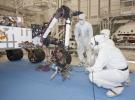 Test operators in a clean room at NASA's Jet Propulsion Laboratory monitor some of the first motions by the robotic arm on the Mars rover Curiosity after installation in August 2010. The arm is shown in a partially extended position.
