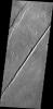 Termed both 'catena' and 'fossae,' long linear depressions created by tectonic forces are a dominate surface feature of Alba Mons in this image captured by NASA's Mars Odyssey spacecraft.