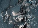 This image from NASA's Mars Reconnaissance Orbiter shows blocks of bright, layered rock embedded in darker material that are thought to have been deposited by a giant flood that occurred when Uzboi Valles breached the rim of Holden Crater.